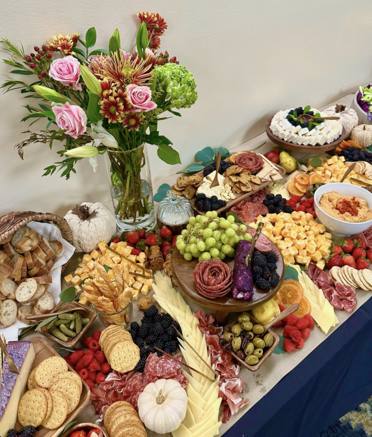 Autumn grazing table with cheeses, charcuterie roses, bread and florals